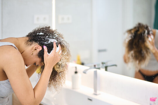 Black female applying hair mousse