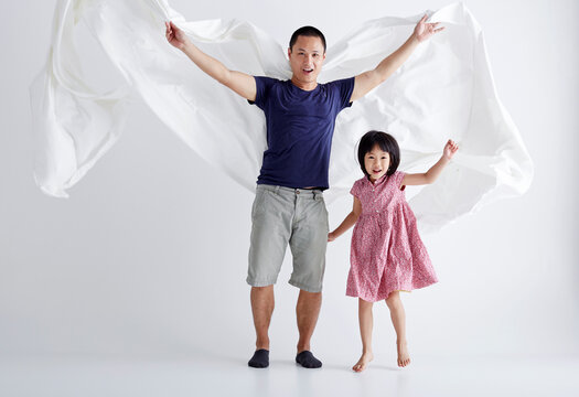Asian father and daughter play cloth game