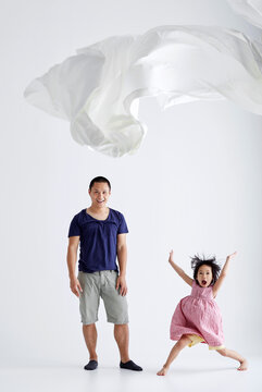 Asian father and daughter play cloth game