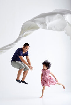 Asian father and daughter play cloth game