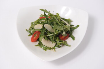 Fresh salad of different vegetables with sauce on a serving plate.