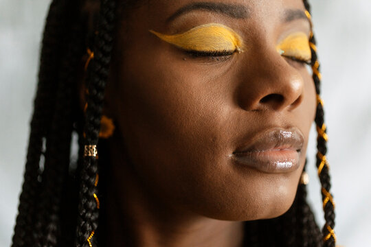 Closeup of Woman with braided hair and creative colorful yellow makeup