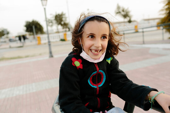 Naklejki Happy gap-toothed kid laughing outdoors in windy day.