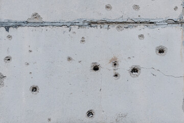 Holes in the house close-up. The result of rocket or artillery shelling of residential premises in...