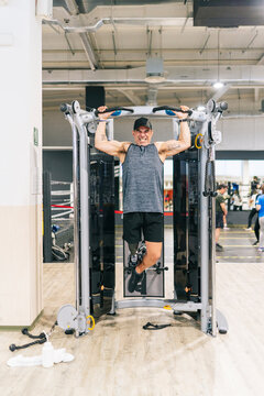 Sportsman with leg prosthesis doing pull ups