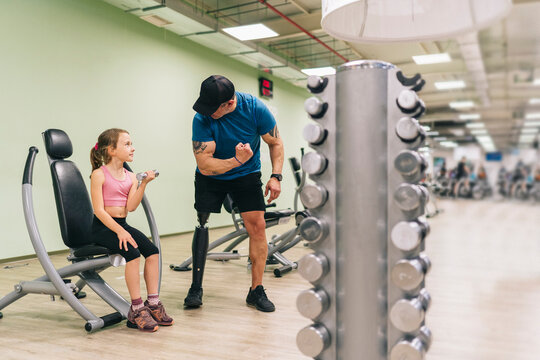 Sporty father with bionic leg with daughter in gym