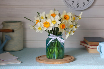 bouquet of daffodils in a glass vase. rustic style, cottagecore.