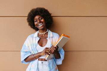 Cheerful black woman with notebook