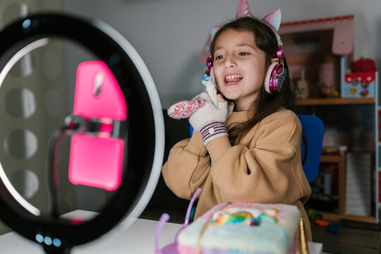 Merry girl shooting video with toy