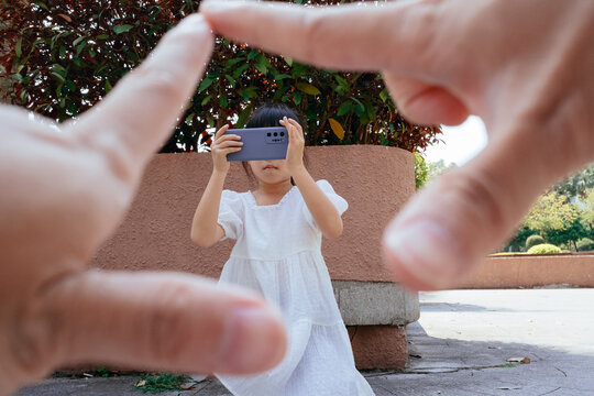 little girl taking pictures with cell phone
