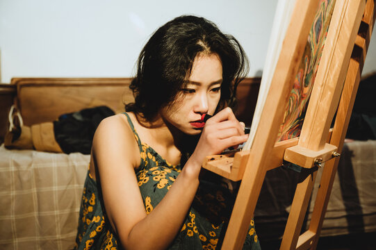 A young woman painting at home