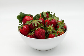 Fresh strawberry in a bowl isolated on white background.
