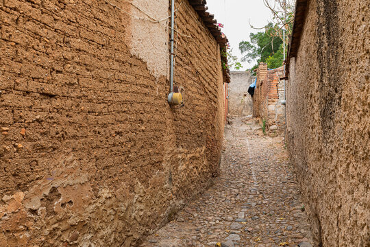 A stone path in the middle of adobe houses