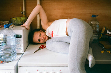 Girl in pyjamas at home fixing the stove with a pair of scissors