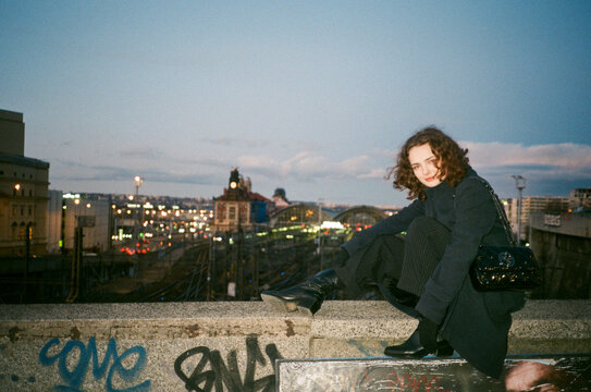 Woman sitting over a wall in fron of Praga's central train station