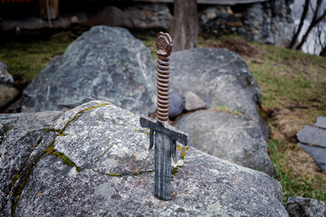 famous sword excalibur of King Arthur stuck in rock. Edged weapons from the legend Pro king Arthur.