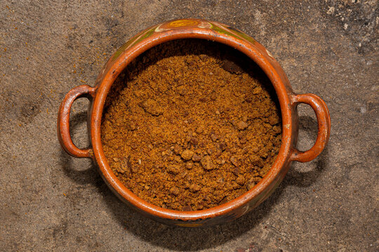 Top view of ground piloncillo or sugar cane inside a clay pot 