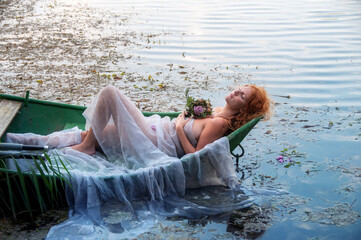beautiful sexy young abandoned woman, bride, Lady of Shalott, lies eagerly left with a bouquet of...