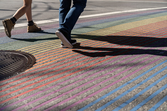 People crossing road on the rainbow zebra