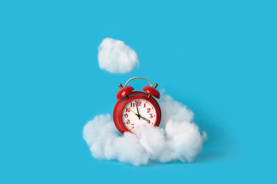 Alarm clock standing in a white cloud