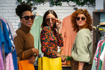 Multi ethnic group of women trying on sunglasses in shop
