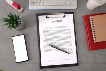 Contract papers and pencil on wooden desk with smartphone on the side and empty screen for mockup.