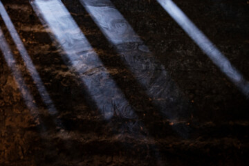 Sunlit cooking smoke in front of an adobe wall 
