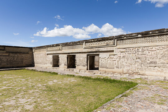 Patio with grass and walls of the archaeological ruins of Mitla