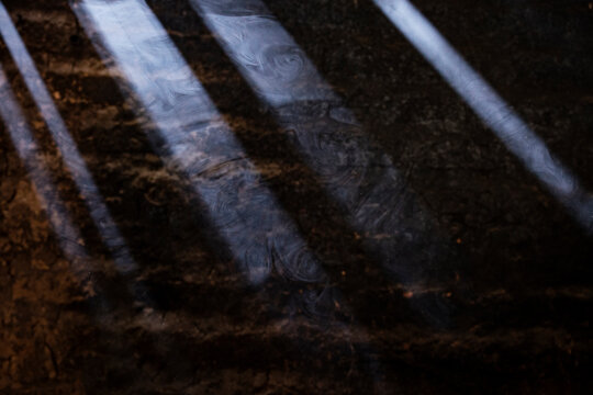 Sunlit cooking smoke in front of an adobe wall 