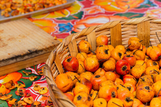 Basket full of tejocotes on a flower tablecloth 