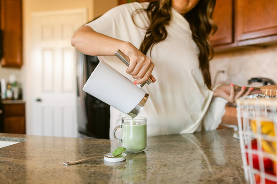 Female making matcha latte during breakfast time