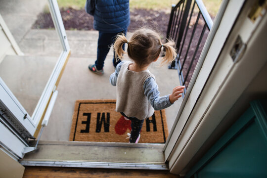 Little Girl In Pigtails Leaves Walks Out Of Front Door Of Her Home