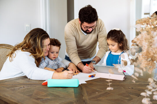 Family drawing together at table at home
