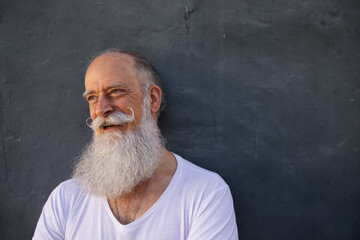 Moustache man leaning on textured blue wall.