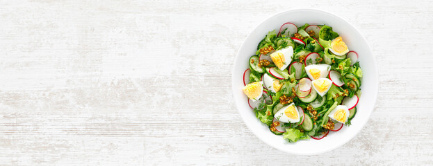 Easter fresh vegetable salad with boiled egg, radish and cucumber, dressing with dijon mustard and...
