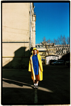 A girl in a yellow and blue raincoat