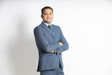 Portrait of a confident young indian business man in a suit standing with his arms cross, isolated on white studio background. successful asian male ceo of company, executive manager. blank space. - obrazy, fototapety, plakaty
