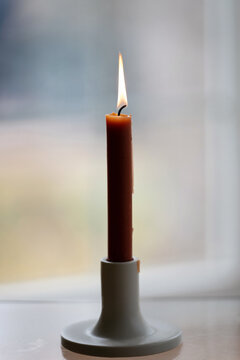 Lit candle burning on table