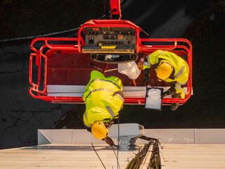 5G network maintenance, technicians work on a building using the lift