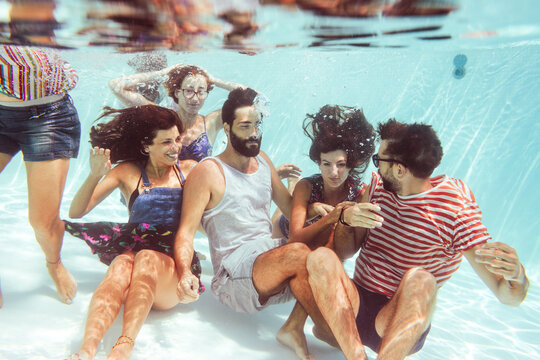 Friends having fun together inside swimming pool