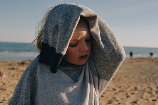 A portrait of a blond kid in enormous sweater