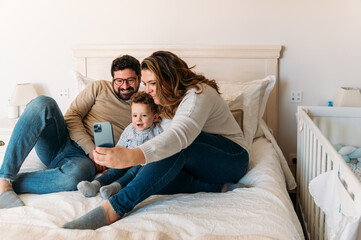 Cheerful family taking selfie on smartphone