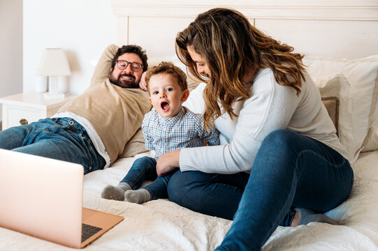 Family watching cartoon with child on laptop