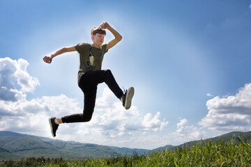 Sports guy in a jump. High jump in the mountains. Summer landscape. Ukrainian Carpathian mountains.