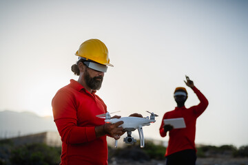 Drone engineers working with futuristic glasses on construction site - Aerial engineering concept
