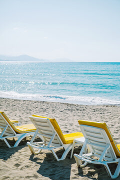 Empty yellow beach chairs waiting for tourists