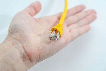 Women hand's holds yellow RJ-45 cable