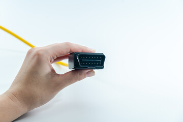 Yellow car diagnostic OBD2 cable in hand isolated