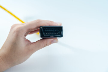 Yellow car diagnostic OBD2 cable in hand isolated