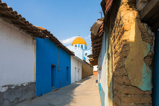 A blue church with its yellow dome and a clean blue sky